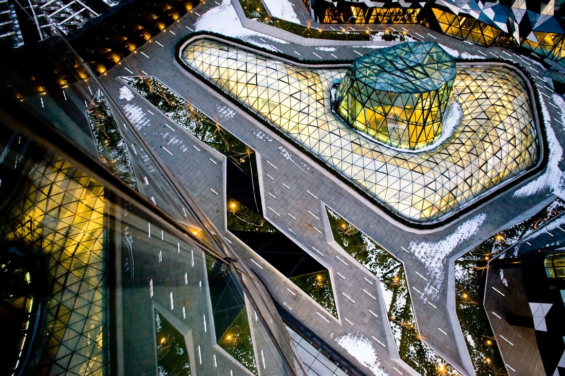 Aerial photograph of a glowing triangulated glass pavilion in snow, Beijing, by Blain Crellin